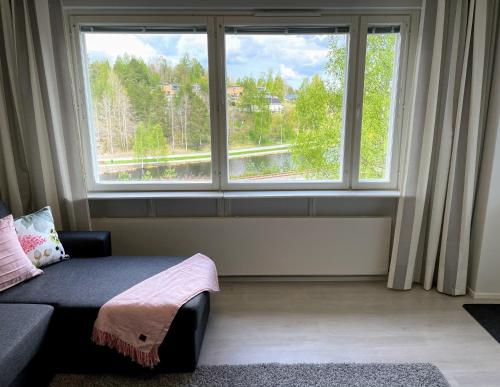 萨翁林纳Citykoti Kuutti的一间配有沙发和大窗户的客房