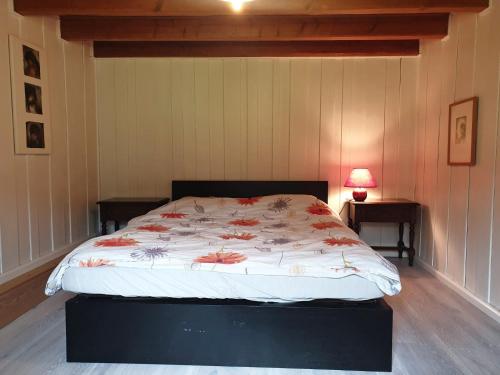 La BrévineLe Petit Brouillet du bas的一间卧室配有一张带鲜花棉被的床
