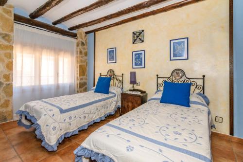 贝塞特洛费雷乡村民宿的一间卧室配有两张带蓝色枕头的床