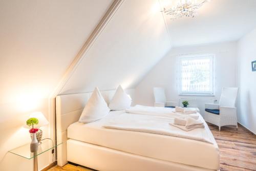 塞巴特阿尔贝克舒尔茨旅馆的阁楼卧室配有白色床