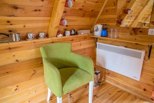 扎布利亚克Cottage Borje的木墙客房的绿色椅子