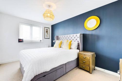 斯旺西Chic City Centre Apartment With Allocated Parking的蓝色卧室设有一张大床和一面黄色镜子