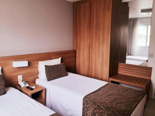 MELHOR LOCALIZAÇÃO NA BARRA DA TIJUCA- Apartamento com Ar, wifi, microondas客房内的一张或多张床位