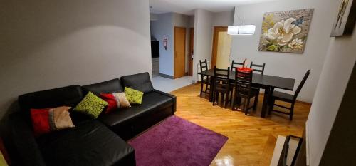加亚新城Apartamento Francelos Condominio的客厅配有黑色沙发和桌子