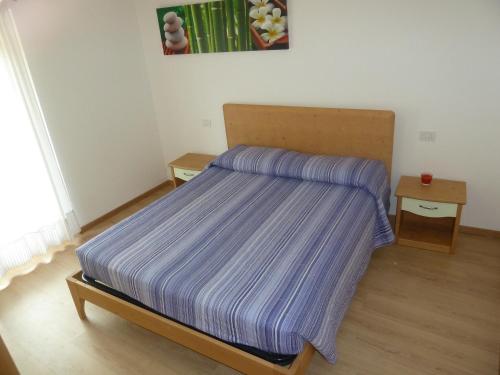 德利纳马索加特姆公寓的一间小卧室,配有一张带紫色床罩的床