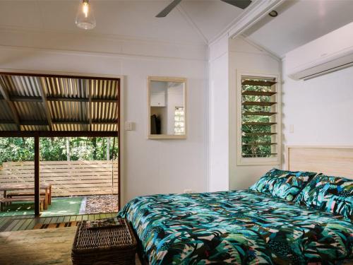 耐莉湾小树丛度假屋的一间卧室设有一张床和一个滑动玻璃门