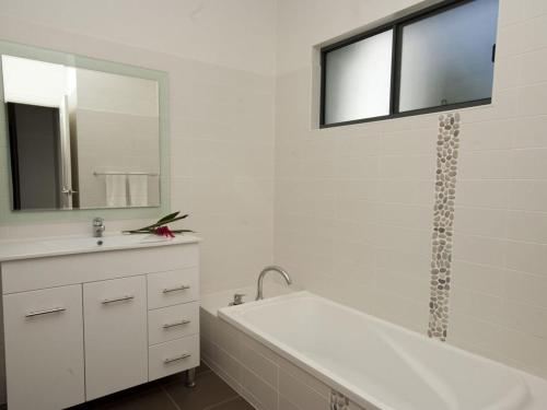 阿卡狄亚伍德维尔海滩联排别墅6号度假屋的带浴缸、水槽和镜子的浴室