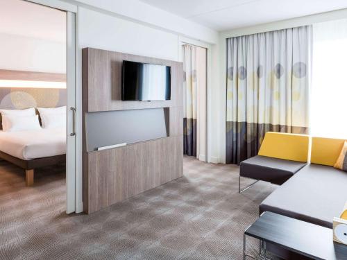 霍夫多普诺富特阿姆斯特丹史基浦机场酒店的酒店客房,配有床和电视