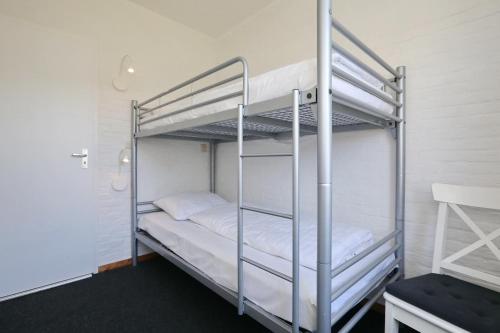 诺德克豪特Holiday home het Zeepaardje的卧室配有2张双层床和白色床单