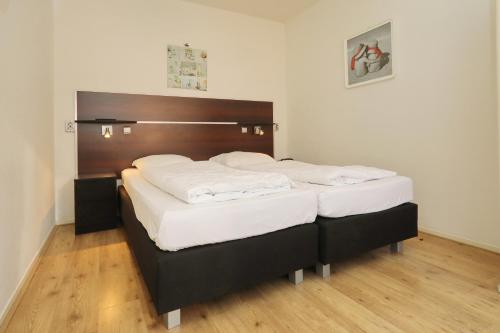 诺德克豪特Holiday home de Zeester的一间卧室配有两张带白色床单的床