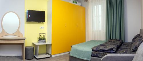 敖德萨泽尼斯酒店的一间卧室设有黄色的门、一张床和镜子