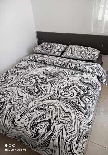 Beʼer OraQuiet place的一张带黑白毯子和枕头的床