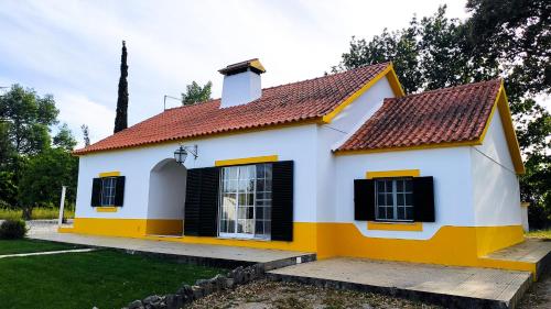 塞图巴尔São Cristóvão Farmhouse Setúbal的黄色和白色的房子,有红色屋顶