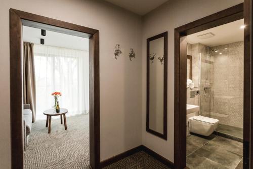 塔特兰斯卡斯特拉ARIETES MARMONT Resort的带淋浴、卫生间和桌子的浴室