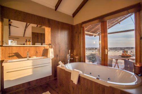 Hardap巴甲卡拉哈里牧场山林小屋的一间带大浴缸和大窗户的浴室