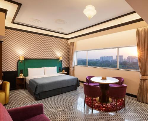 新德里The Connaught, New Delhi- IHCL SeleQtions的酒店客房带一张床、一张桌子和椅子