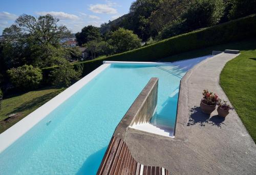 费罗尔Apartamento con piscina y excelentes vistas的一个带围栏和两株盆栽植物的游泳池