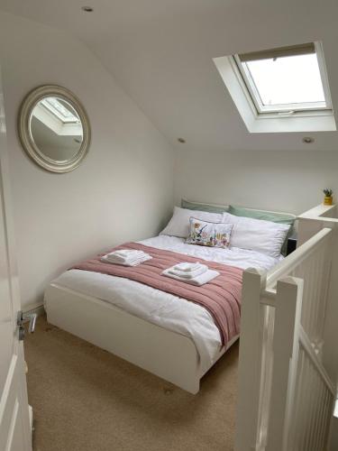 PucklechurchOrchard cottage的白色卧室配有一张带镜子的床