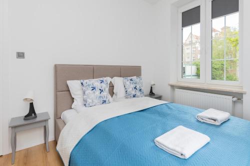 格但斯克Chlebnicka Apartments in Gdańsk Old Town by Renters的一间卧室配有蓝色的床和2条毛巾