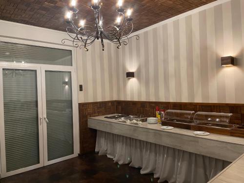 马尔米莱娜餐厅宾馆的厨房配有带水槽和吊灯的台面