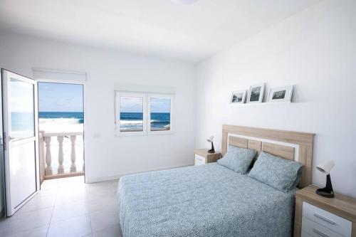 AzanoHorizonte Atlántico: Un Rincón en el Paraíso的一间卧室配有一张床,享有海景