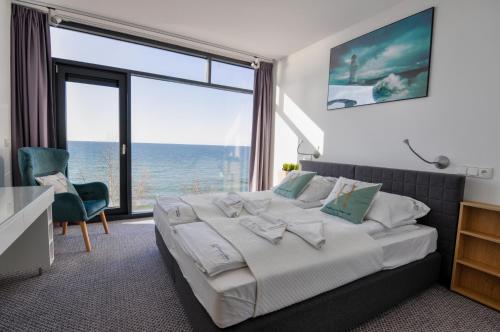 尤斯托尼莫斯基Apartament Nadmorski Luksus - Boulevard的一间卧室设有一张大床,享有海景
