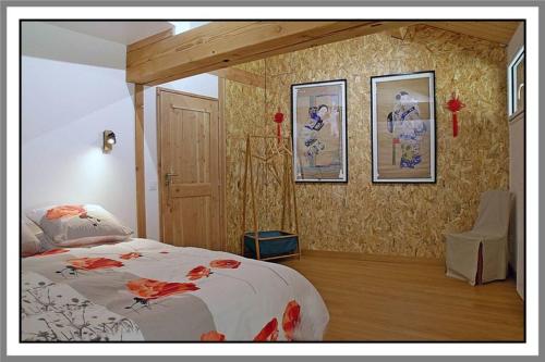 CerdonLES CHAMBRES DE LIANE的一间卧室配有一张床,墙上挂着一些图片