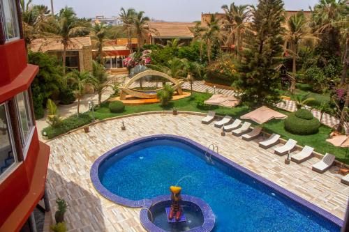 达喀尔Iris Hotel的享有带躺椅的游泳池和度假村的顶部景致