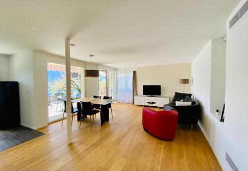 锡格里斯维尔Panorama Boutique Apartment with Air Condition, SPA entry in Solbadhotel的客厅配有红色椅子和桌子