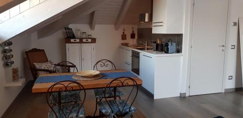 贝拉吉奥Bellagio Holiday Home的一间带桌椅的厨房和一间带白色橱柜的厨房