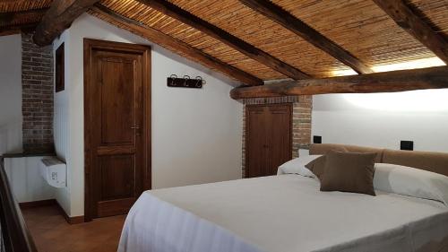 PresaLa Gelsomina - Etna的卧室设有白色的床和木制天花板。