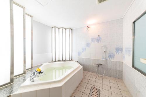 神户甜教堂酒店（仅限成人）的白色的浴室设有浴缸和淋浴。