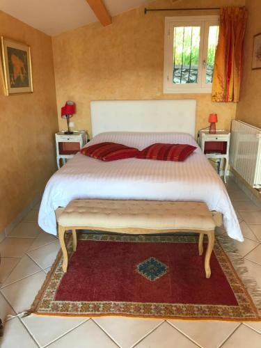 耶尔Les Trèfles的一间卧室配有一张大床和红色地毯。