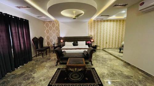 拉希迈尔汗Golden Sand Hotel Rahim Yar Khan的卧室配有一张床和一张桌子及椅子