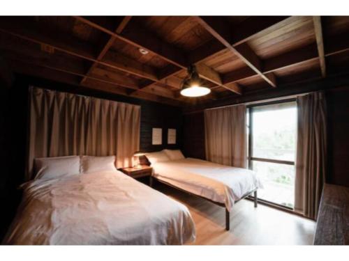 InbuLOGIN OKINAWA -wood- - Vacation STAY 33434v的一间卧室设有两张床和窗户。