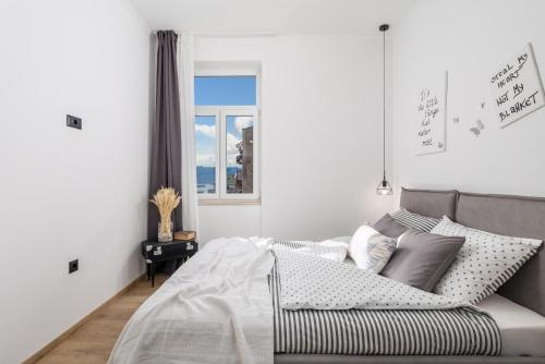 里耶卡Apartment Vintasio的白色的卧室设有床和窗户