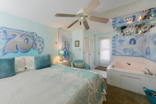 北怀尔德伍德Summer Nites的蓝色卧室设有1张床、浴缸和1张床