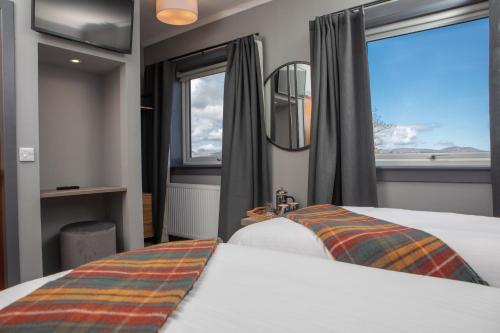 布罗德福德Hebridean Inn的酒店客房设有两张床和窗户。