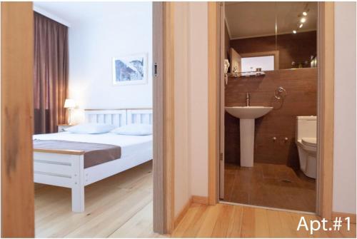 梅斯蒂亚svaneti apartment's的一间卧室配有一张床,浴室设有水槽