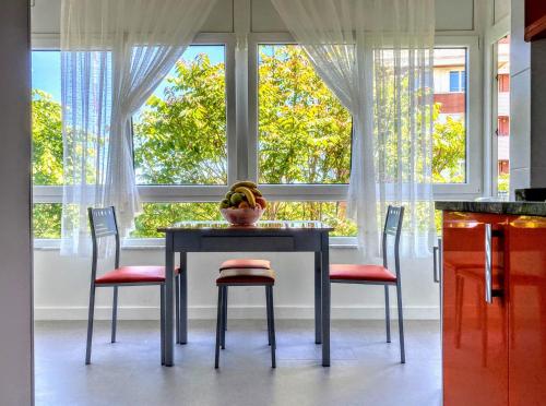 桑坦德Apartamentos Las Calas的餐桌,配有两把椅子和一碗香蕉