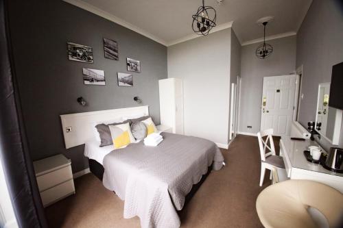 海斯廷斯任思登酒店的卧室配有白色的床和椅子