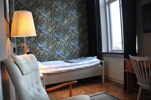 拉霍尔姆拉赫尔姆斯斯塔德酒店的一间卧室配有一张床、一盏灯和一把椅子