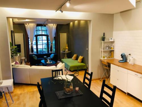 布鲁塞尔安睡公寓酒店的厨房以及带桌椅的起居室。