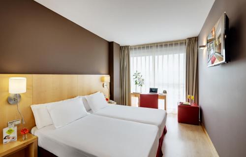 洛格罗尼奥塞尔科蒂尔波塔莱斯酒店的酒店客房设有白色的床和窗户。