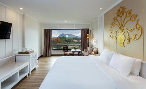 清莱The Riverie by Katathani SHA Extra Plus的酒店客房设有一张白色大床和一个窗户。