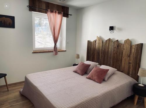 拉布雷斯Le cocon d’Emma的一间卧室配有一张大床和木制床头板