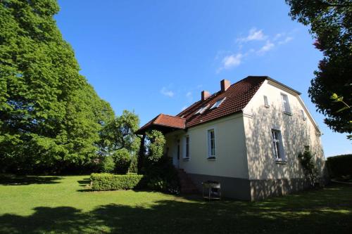 SchönbeckFerienhaus Ratteyer Idyll的草场上的白色小房子