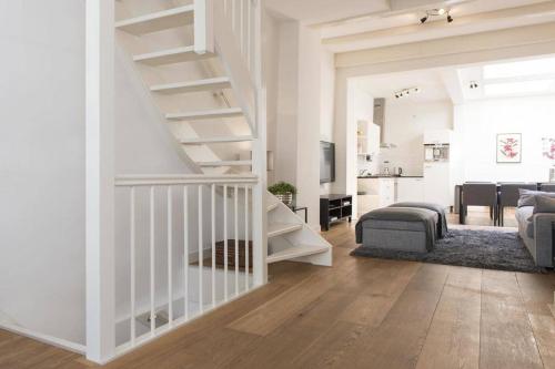 阿姆斯特丹Stylish Canalhouse A的一间设有楼梯的白色客厅和一间客厅