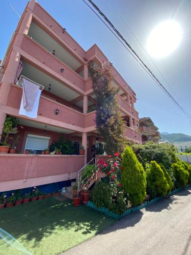 巴尔Apartments Nikičić的粉红色的房子,旁边挂着一条毛巾