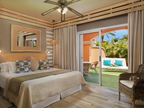 美洲海滩Green Garden Eco Resort & Villas的一间卧室设有一张床和一个滑动玻璃门